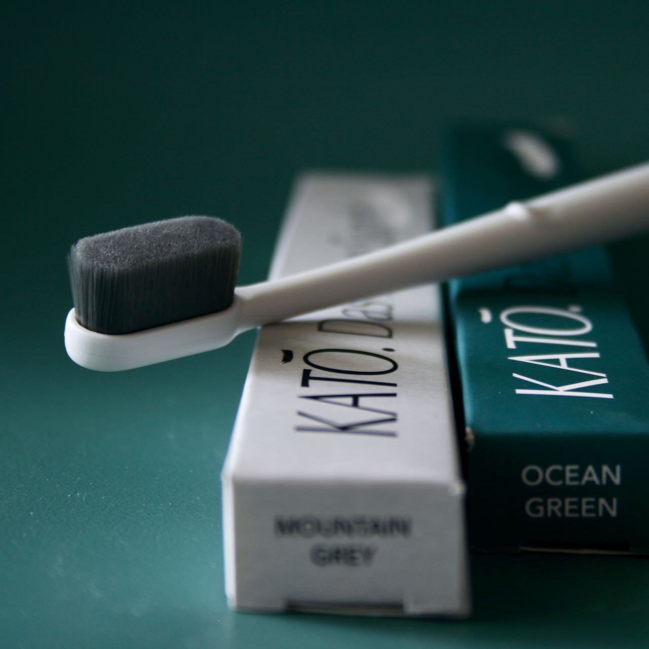 KATO-Zahnbuerste-Mountain-Grey-20000-nano-Borsten-vor-gruenem-Hintergrund