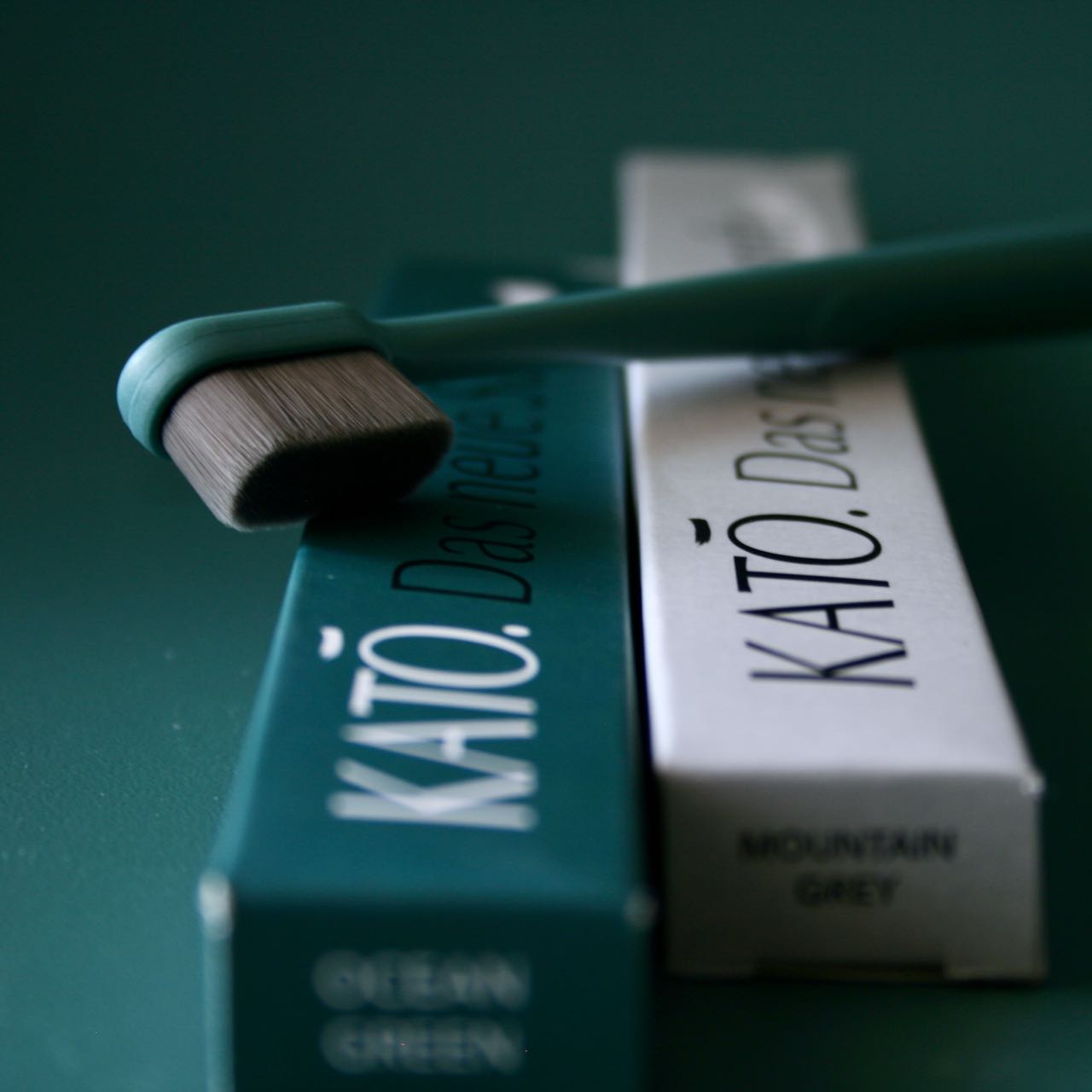 KATO-Zahnbuerste-Ocean-Green-20000-nano-Borsten-vor-gruenem-Hintergrund